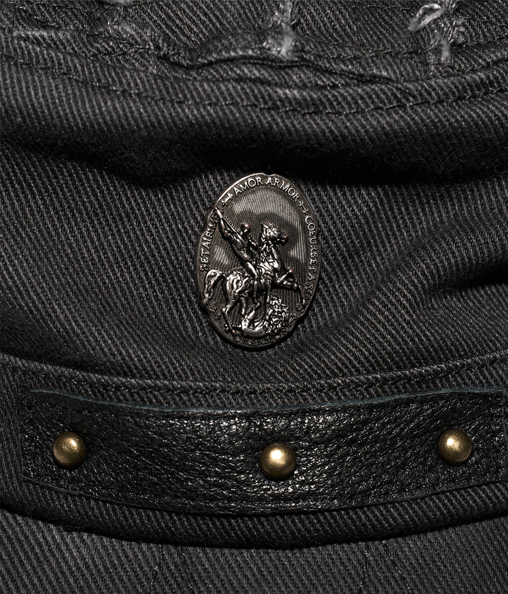 Close-up of a black leather jacket with a brand emblem and studs.
