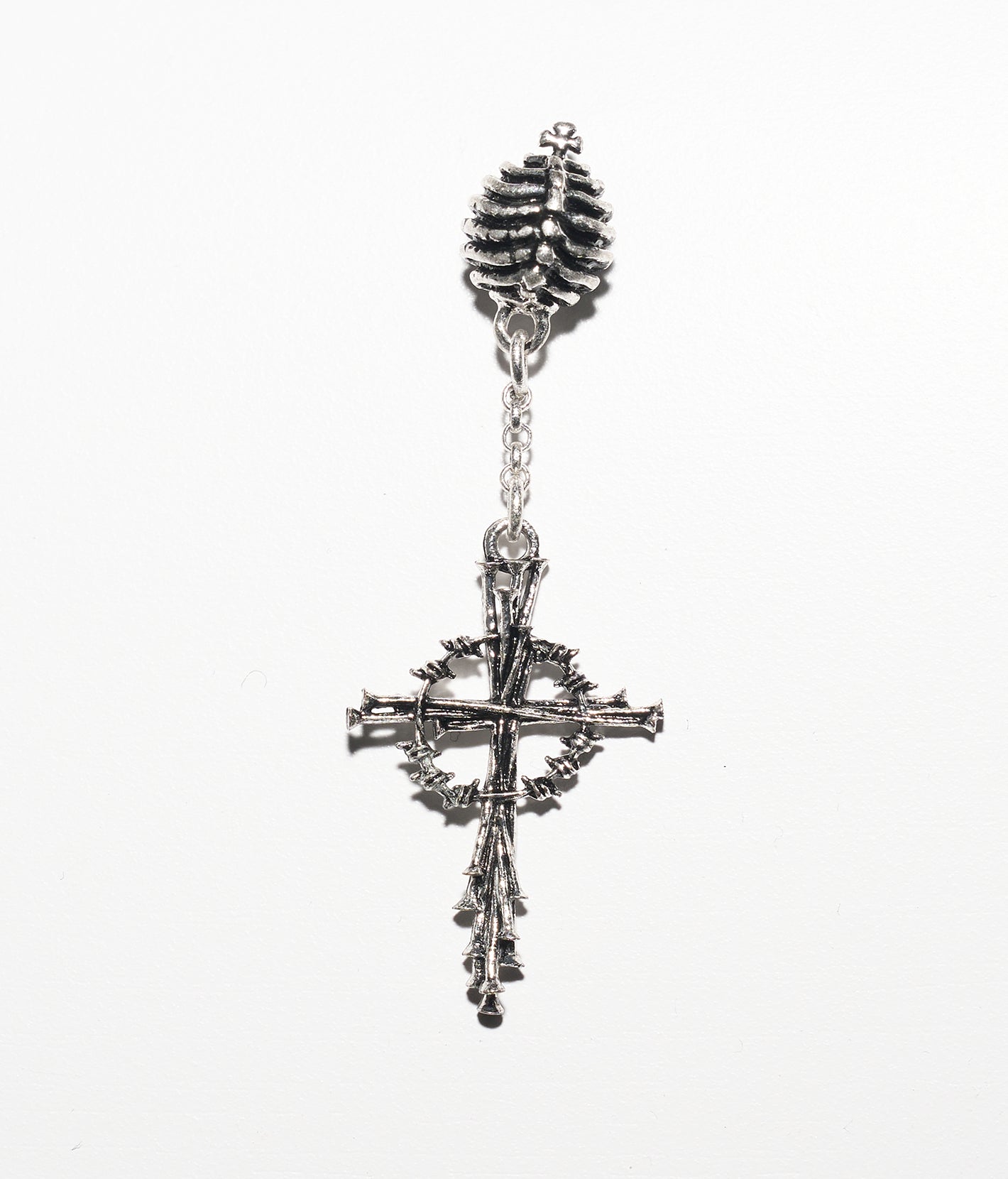 Silver cross earring with intricate design on a white background